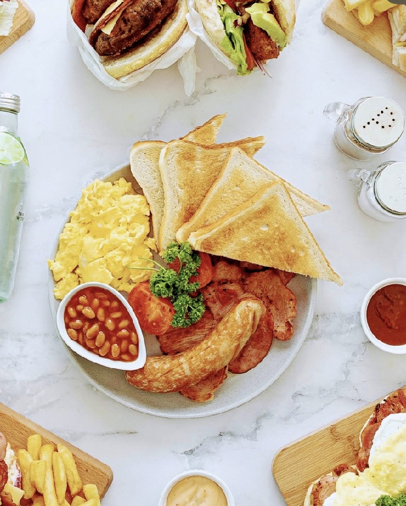 Big breakfast with scrambled eggs, bacon, sausage, beans and toast
